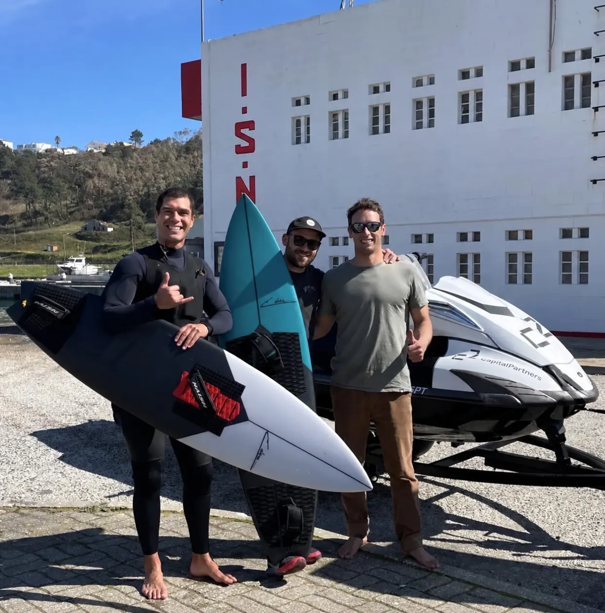 Edu, Ben and Ivo with surfboards and a jet ski