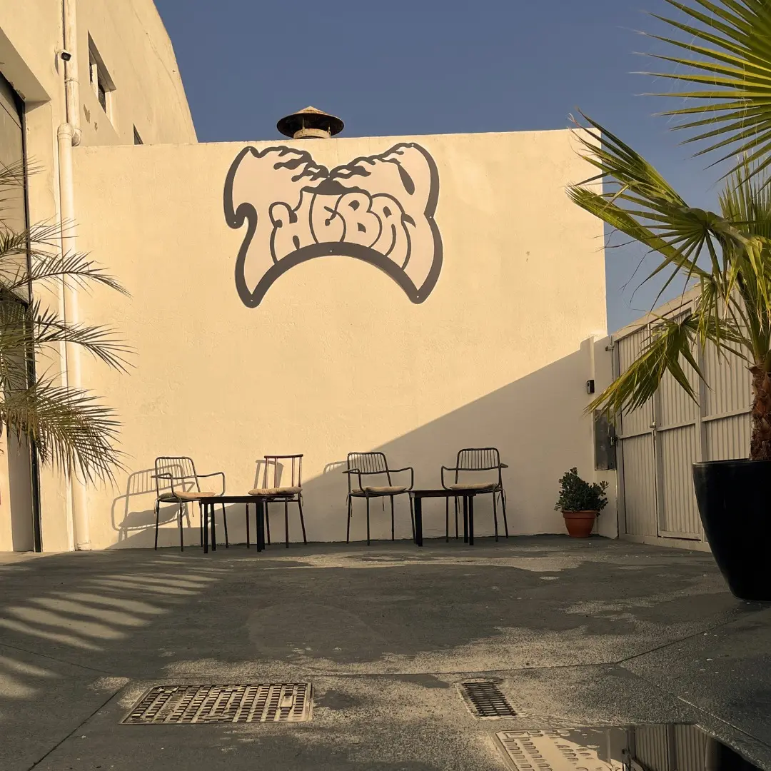 Sunlit courtyard at TheBay with its logo on the wall